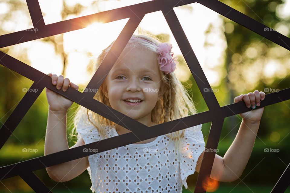 Candid lifestyle portrait of cute little Caucasian girl with blonde hair outdoor 