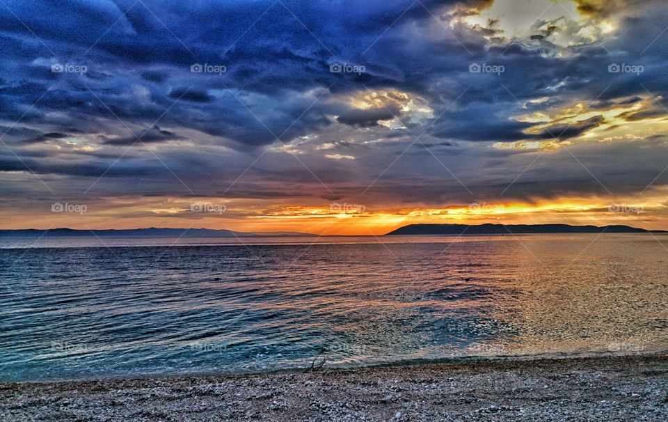 Storm clouds over sea during sunset