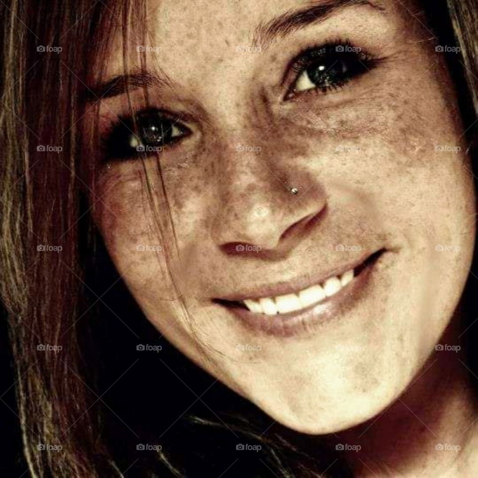 Close up of woman face in sepia color. Freckles and teeth