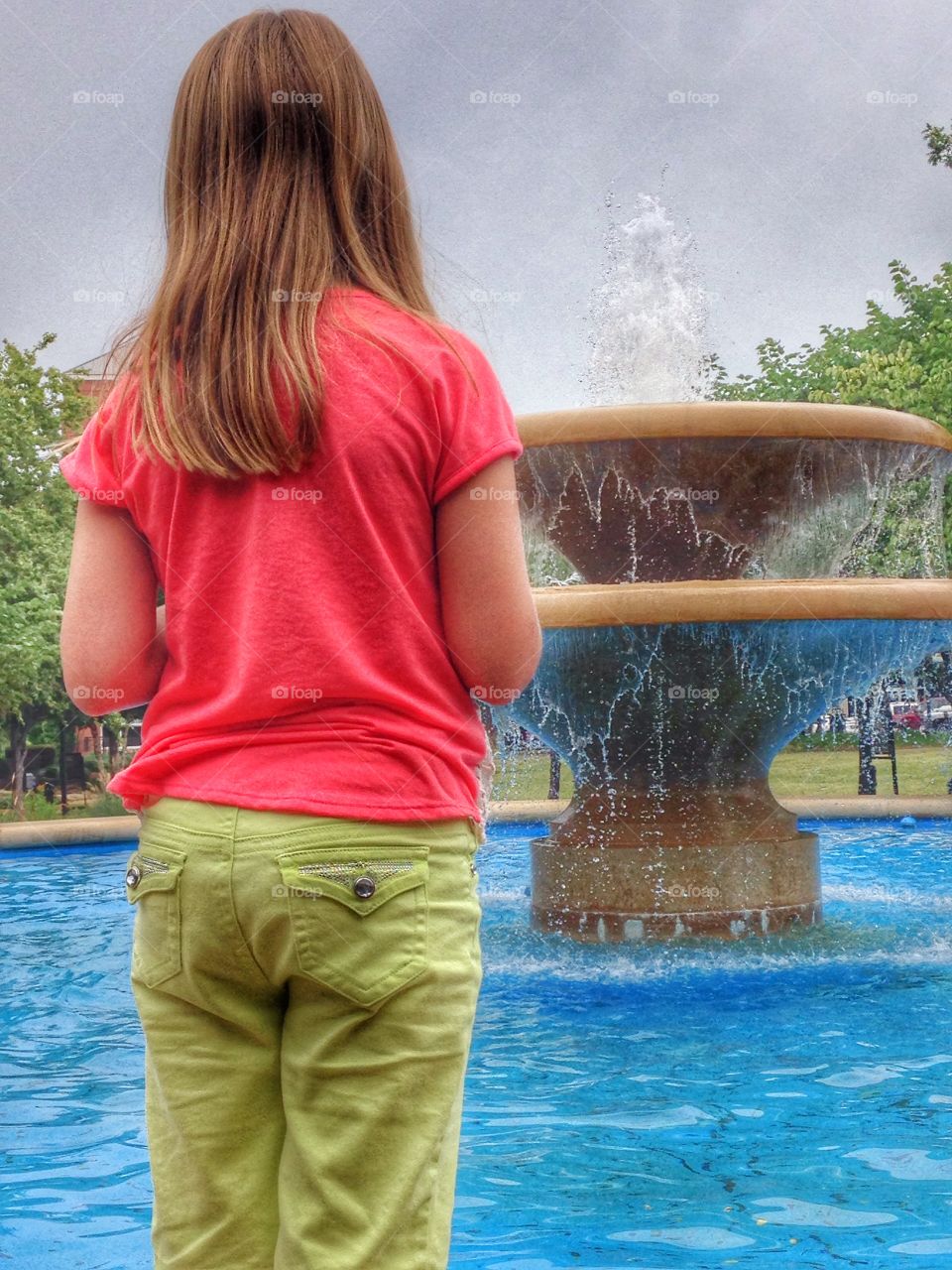 Make a wish. Girl making a wish at a water fountain