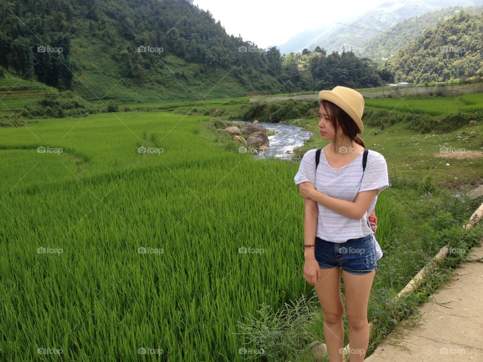 Asian woman looking at rice paddy field