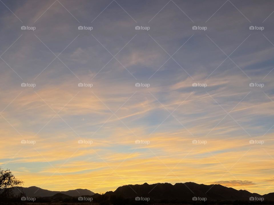 A photo of a colorful sunset with mountains. 