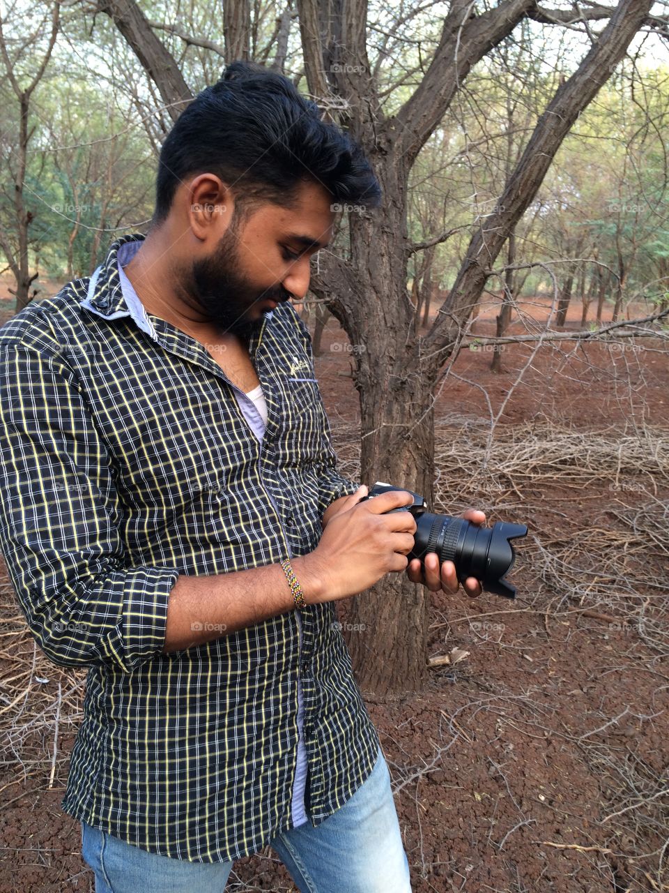 Indian man adjusting camera lens