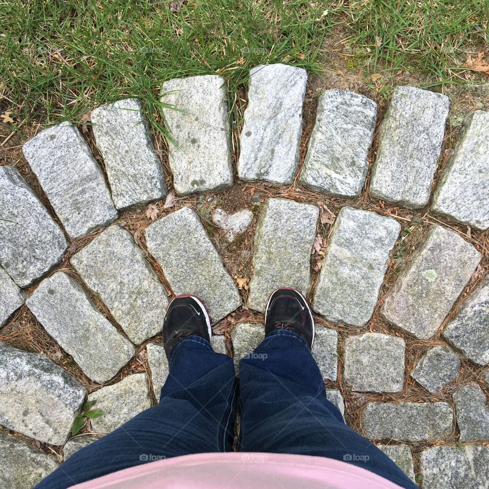 Looking down at my feet standing on front door cobblestone landing. 💛rock at center.