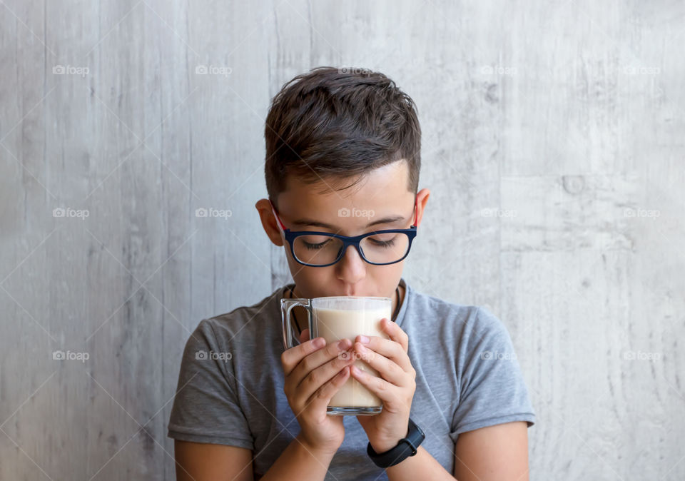 Portrait of child's holding a cup with baked fermented milk and drink it. Healthy lifestyle concept.