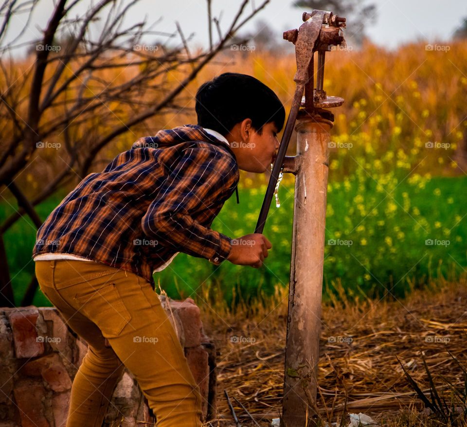 small Boy Drink water from Water Pump