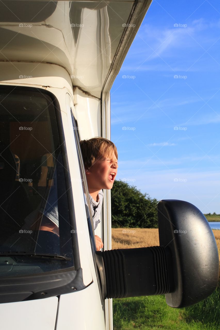 Child leaning out of a motorhome window 