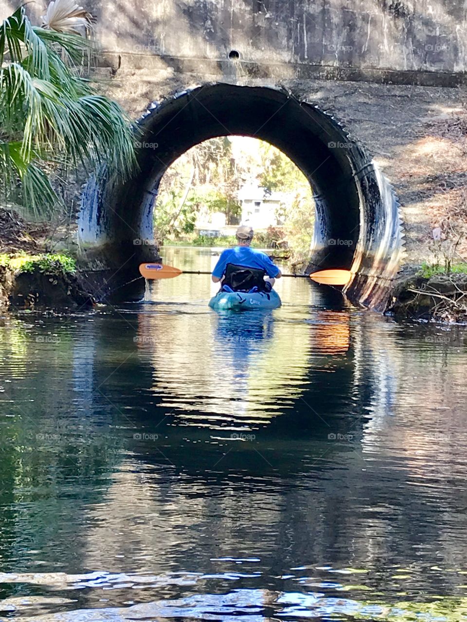 Paddling on the river through the tunnel in crystal clear water