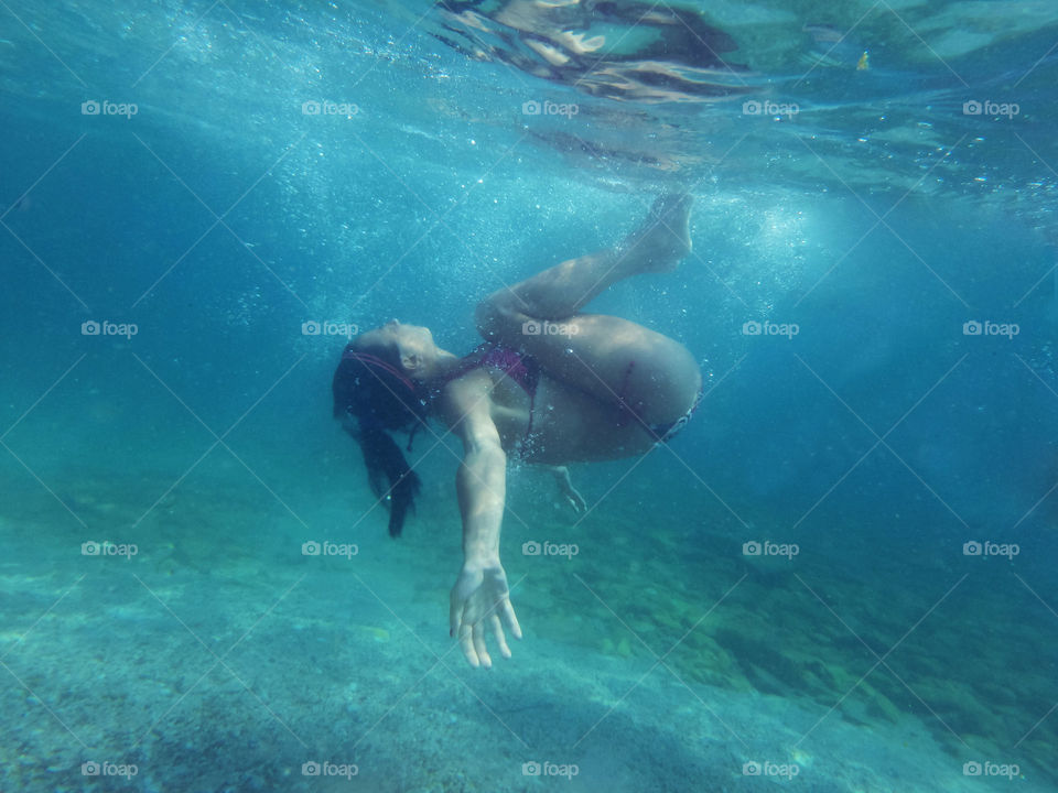 woman underwater making circle. woman model makinh circle shape underwater