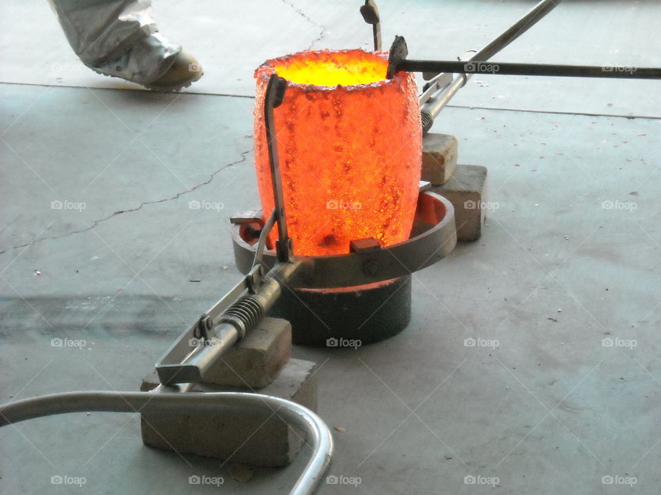2200 degree carbide crucible sitting in pouring tongs.