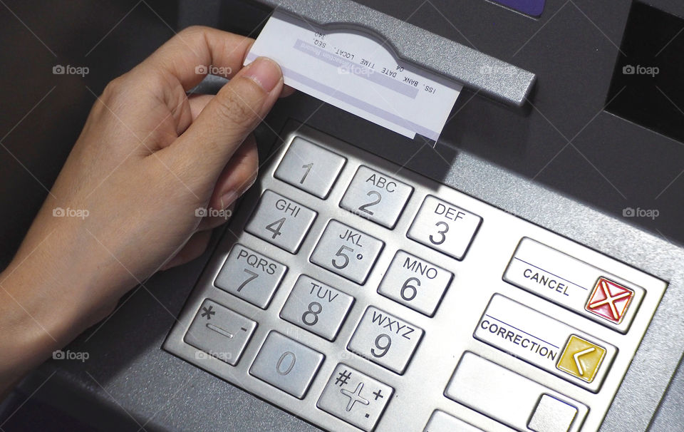 ATM button close-up and paper transaction.