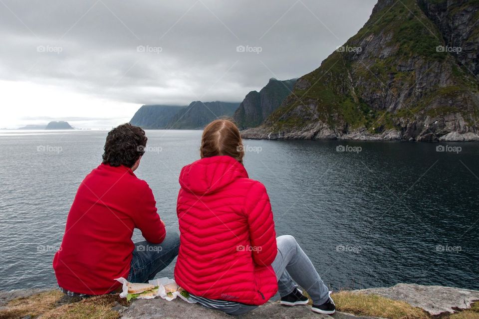 Rear view of a couple sitting near the sea