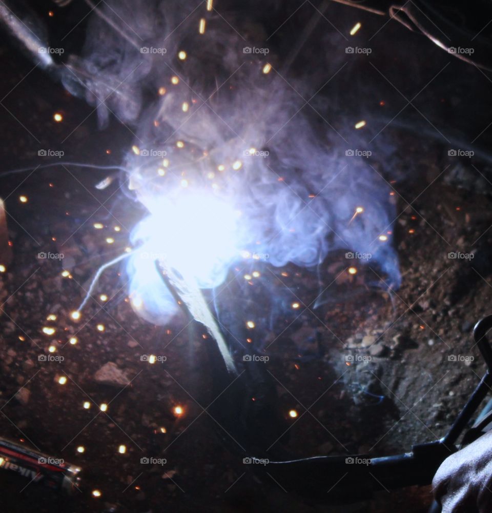 Working on welding causing sparks and puffs of smoke