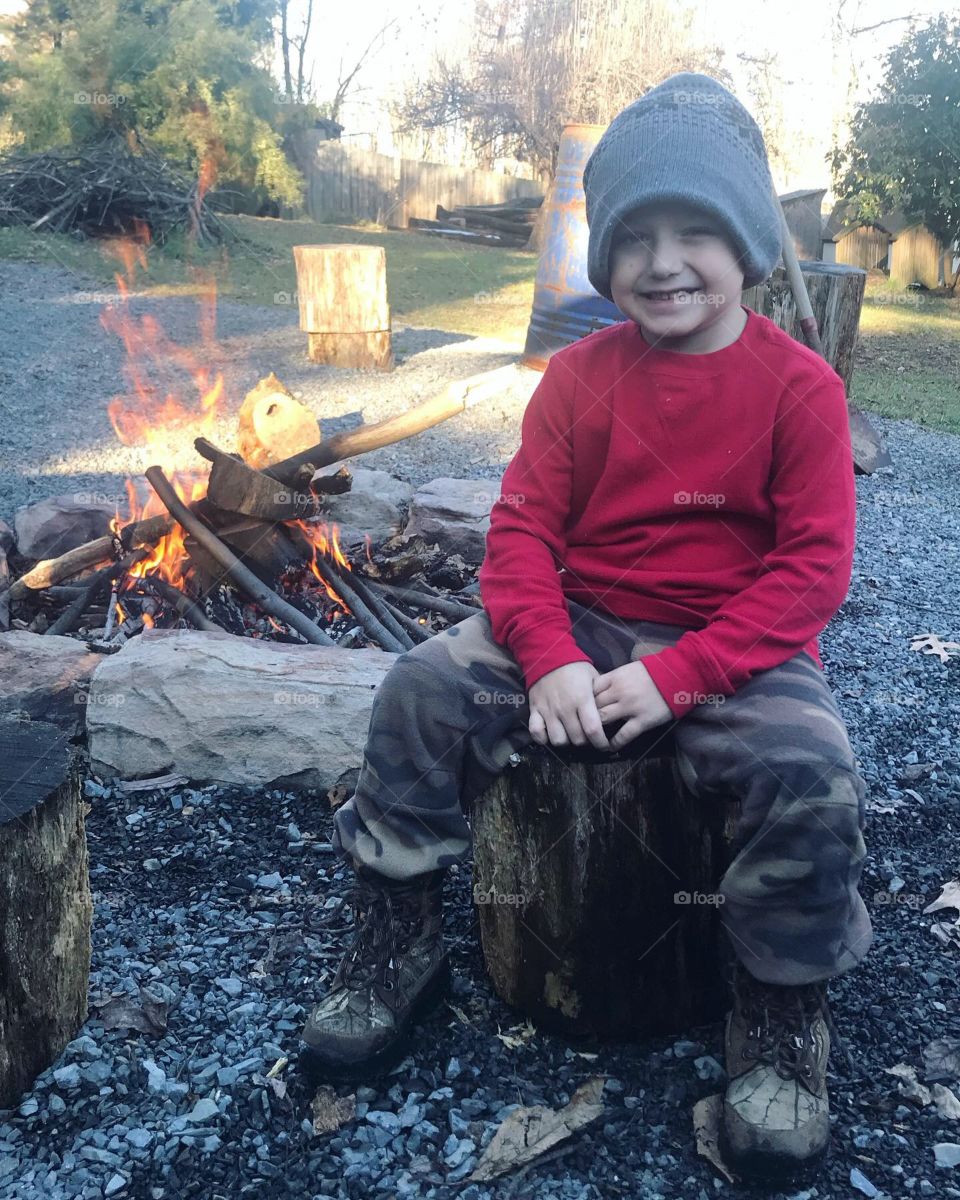 My adorably handsome little son keeping himself warm by the campfire on a crisp day outside. 