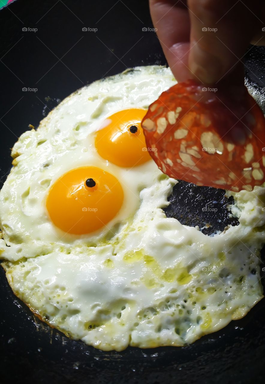 Round fried eggs in the form of a frightened face made of two round yolks