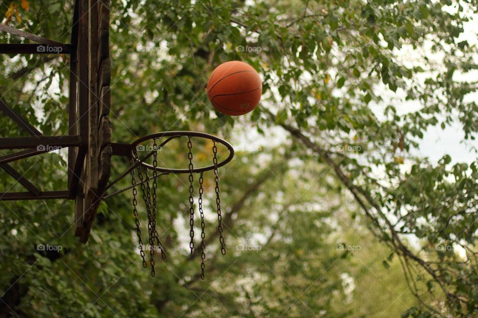Girl throws the ball into the basketball hoop