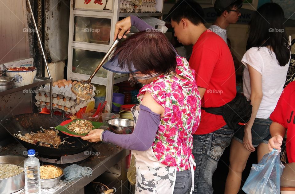 traditional Chinese food, char kuey teow being fried by hawker cook