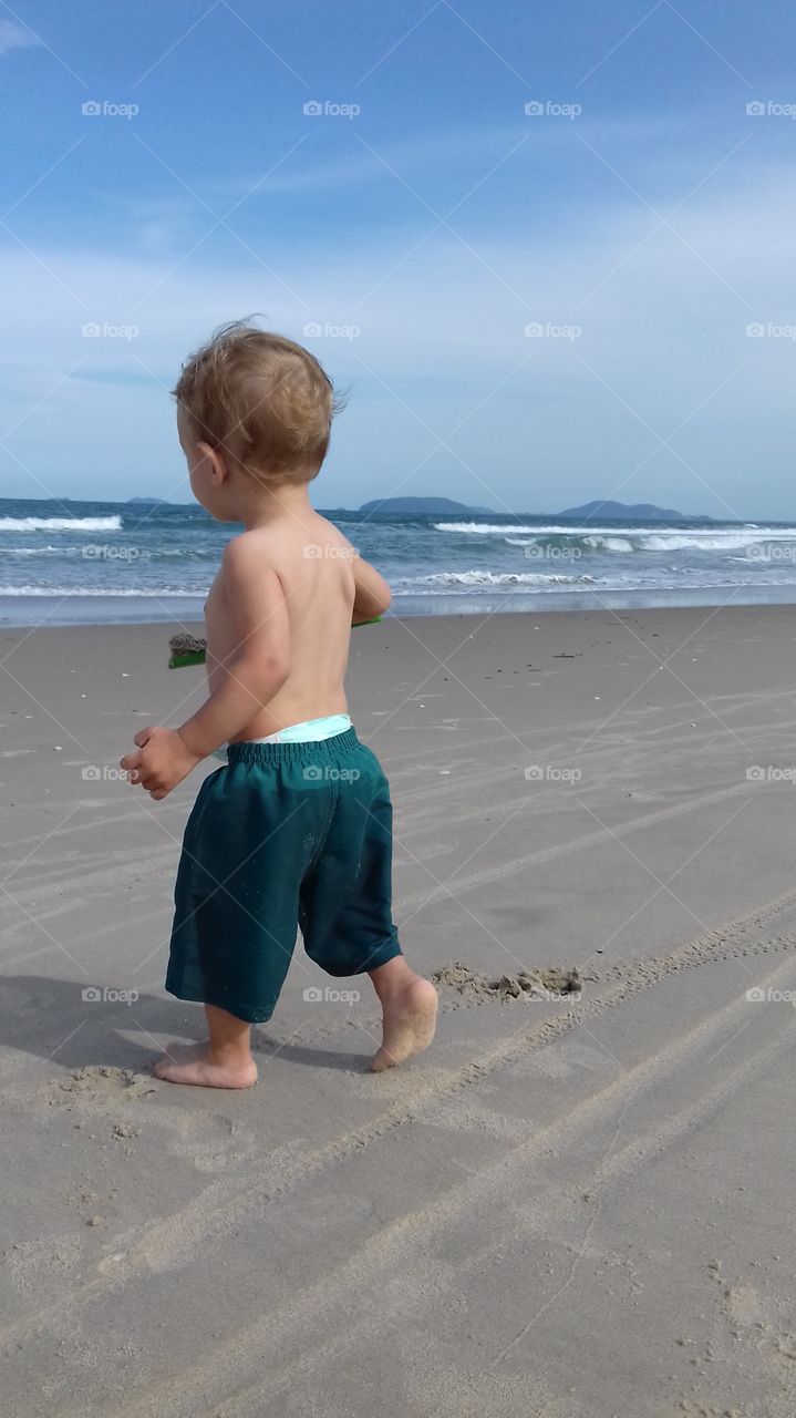 Cute boy playing on sandy beach