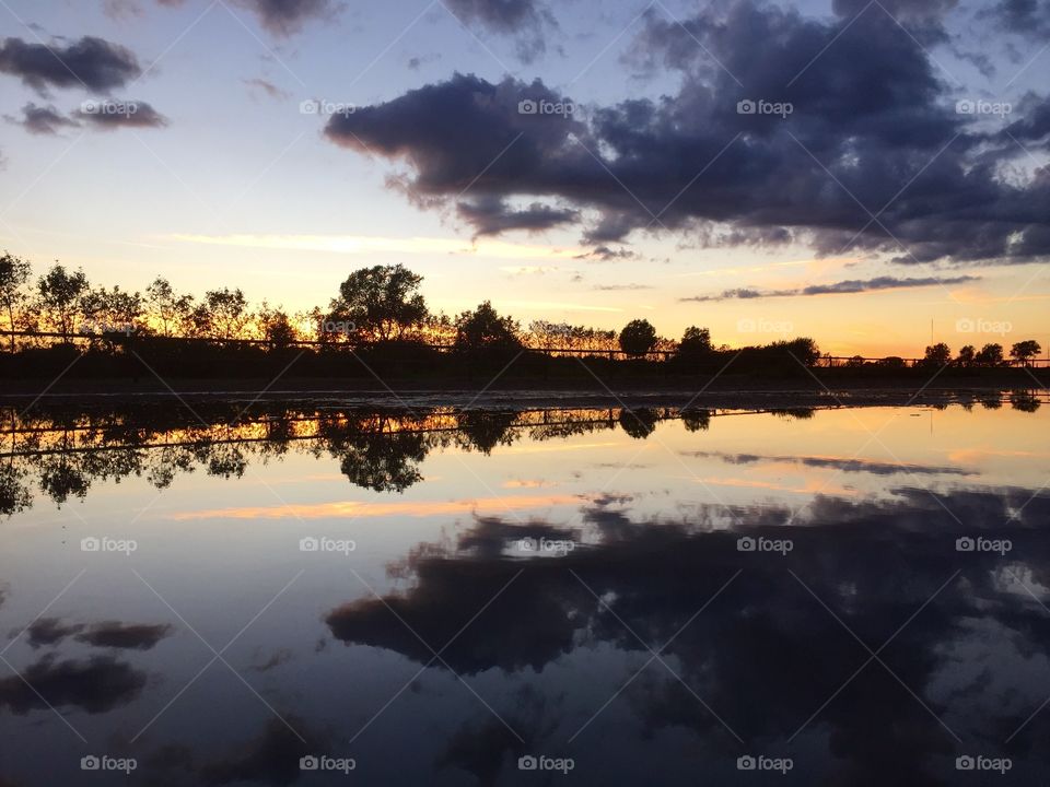 Dramatic clouds reflecting on the lake during sunset