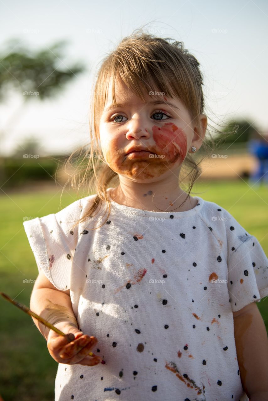 baby girl covered with paint