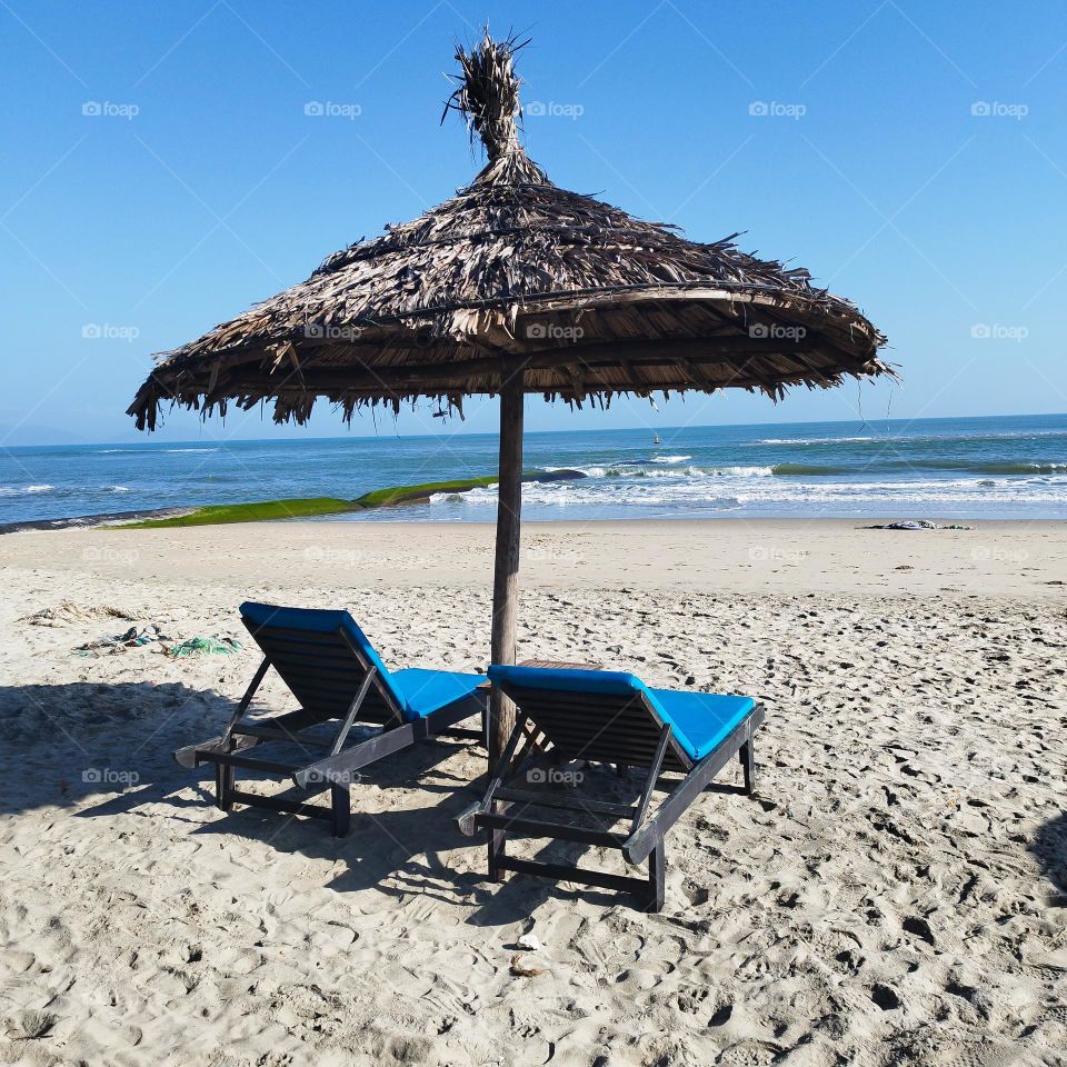 30th January 2025. 08:03. Location: An Bang Beach, Hoi an, Vietnam. Sunbed and a parasol beside the sea.
