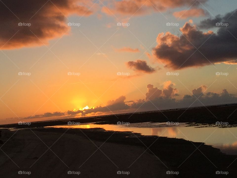 Sunset on Guam, along a sandy path over the ocean