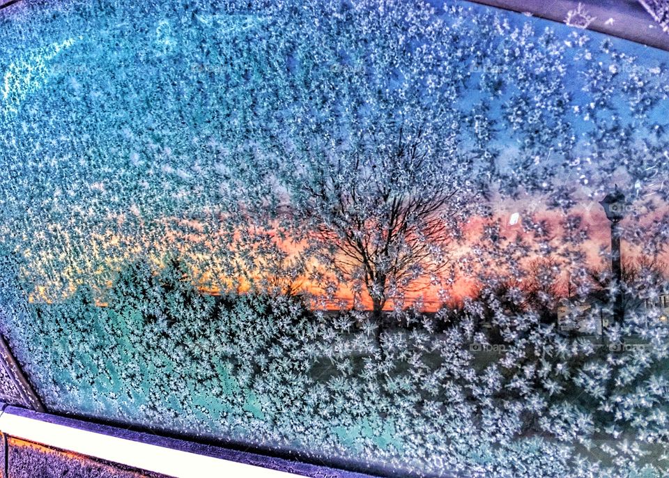 Sunrise reflections on the frosted car window