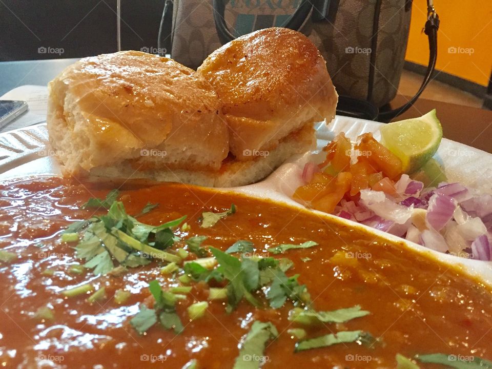 Bread and curry. Indulged in butter. This snack is called Pav Bhaji. Famous in Northern part of India. 