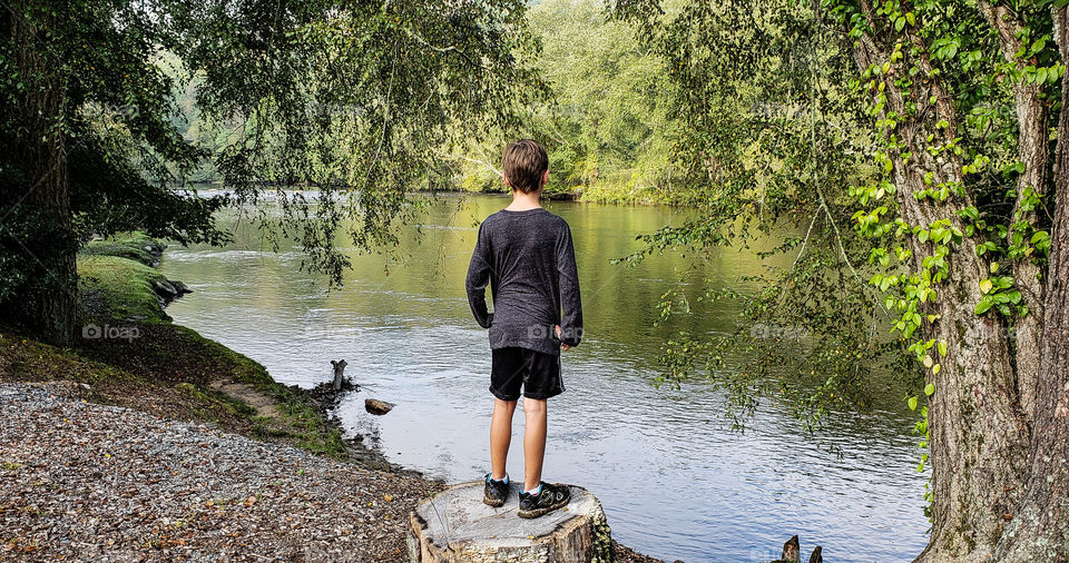 little boy viewing the mountain stream.