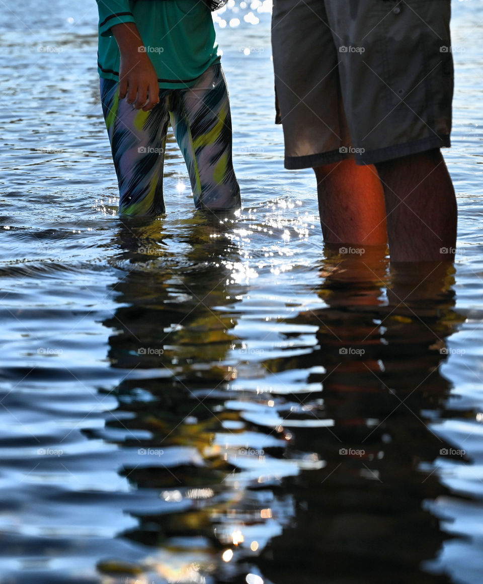 Shadows of daughter and father in the river for nature exploration of the weekend.