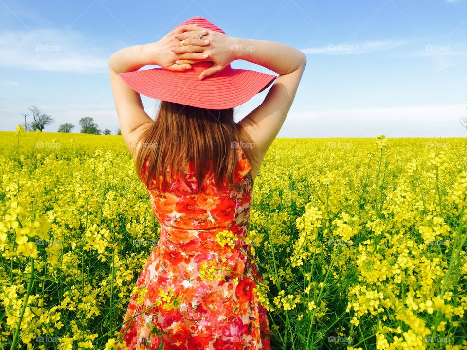 Rear view of woman standing at rape field