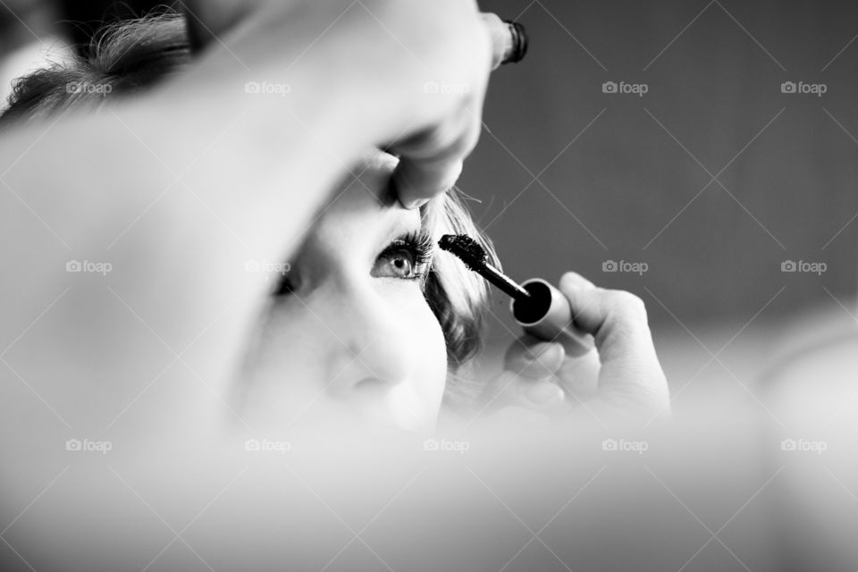 Eyes - image of make up artist putting mascara on, with focus on the girl's beautiful eyes.