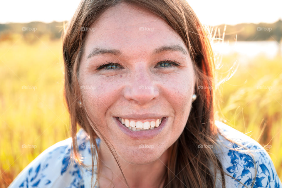 Smiling woman portrait in a field on a sunny day