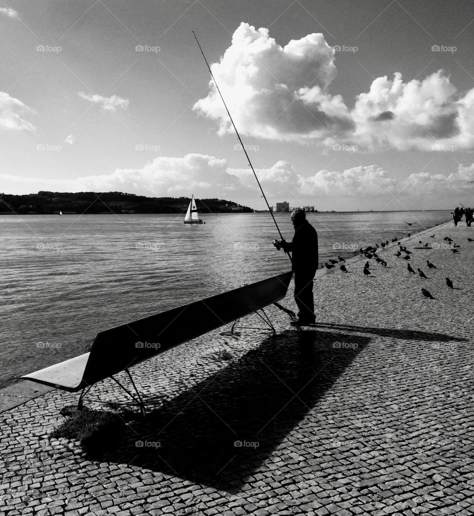 fishing on the bank of the Tagus River, Lisbon, Portugal