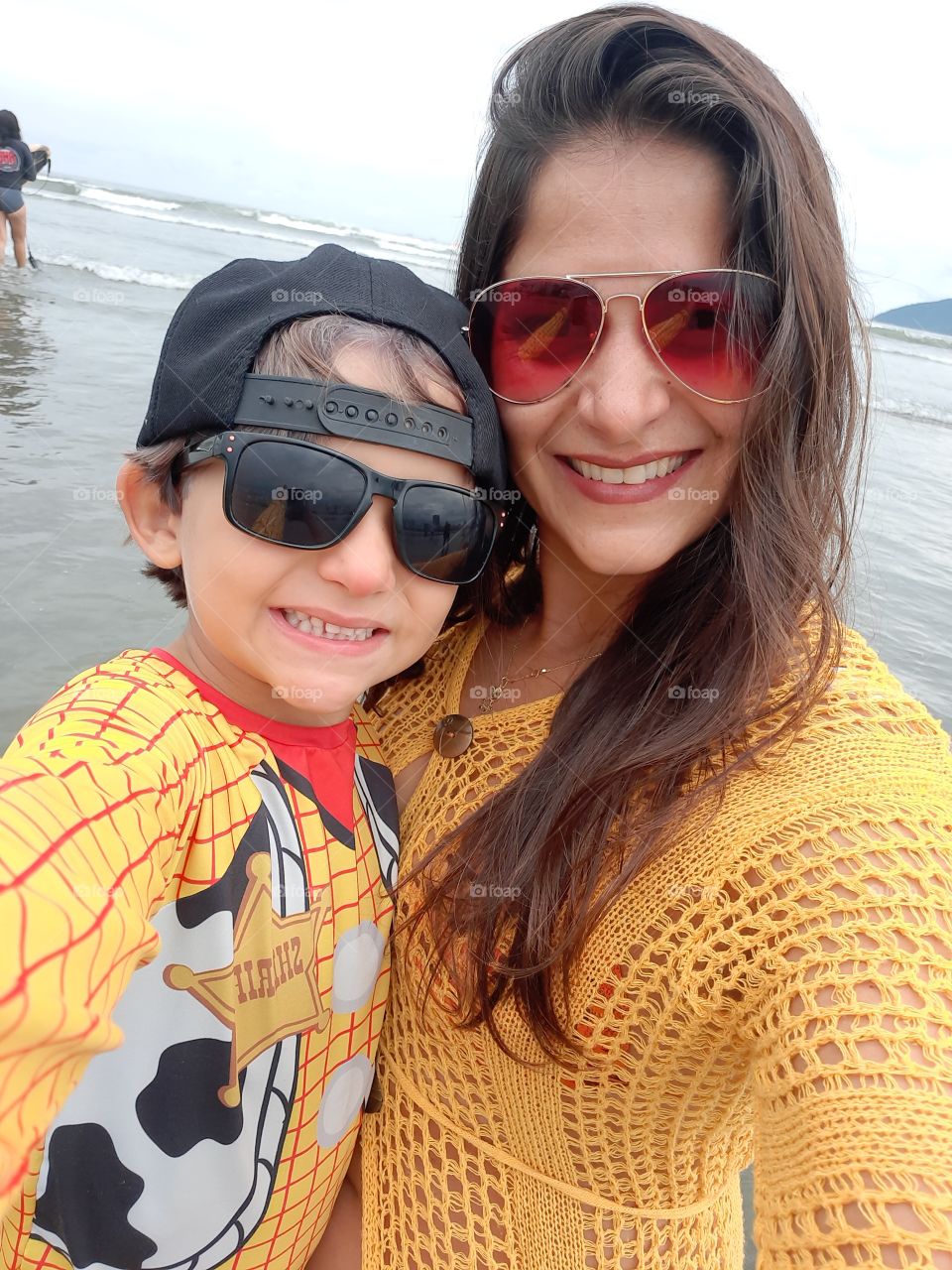 happy mother and son on the beach smiling