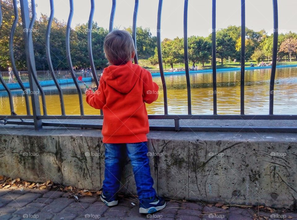 the child looks at the pond  ребёнок смотрит на пруд