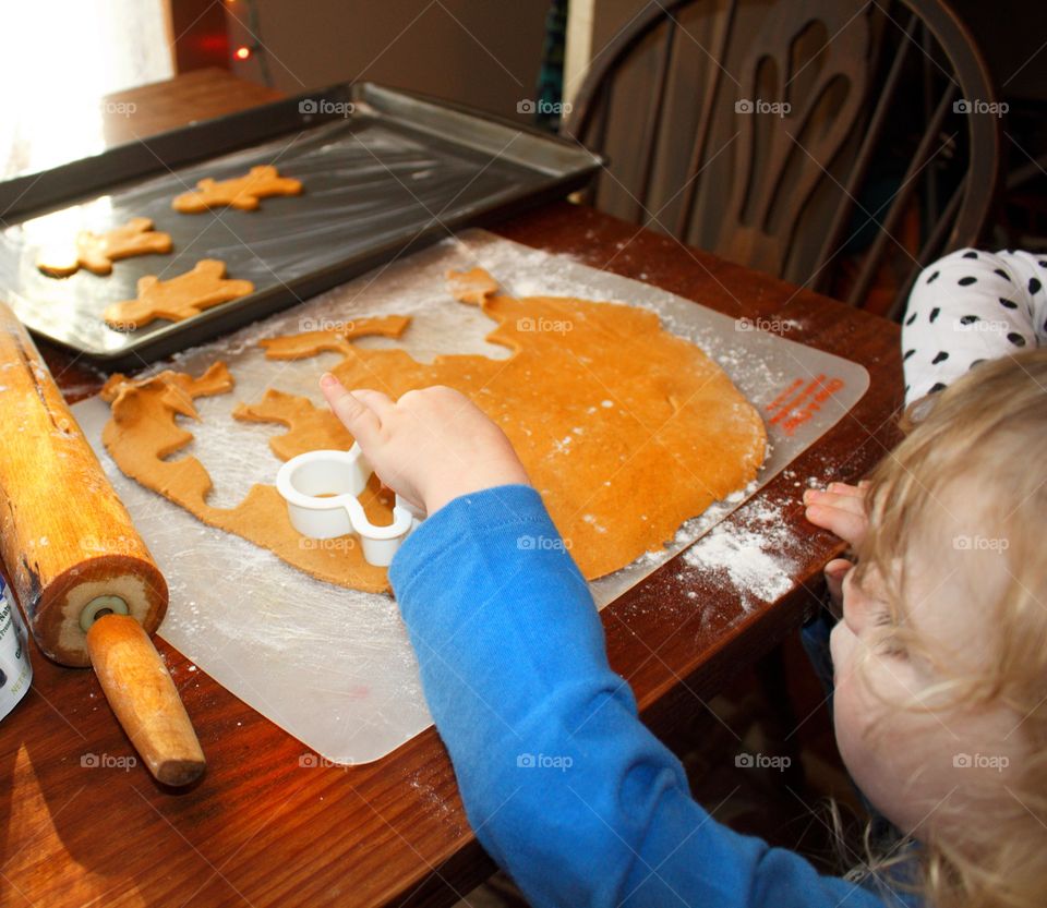 Child making gingerbread men for Santa.