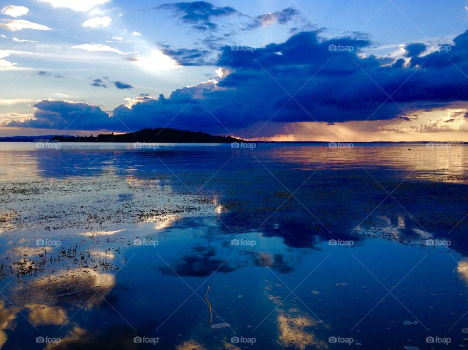 Trasimeno lake. romantic view of Lake Trasimeno at sunset with the island Polvese at the horizon