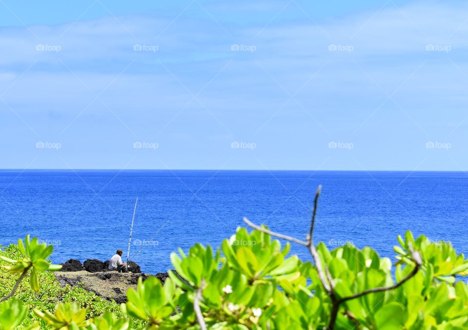 A fisherman working the sea cliffs on the east side of the Big Island of Hawaii