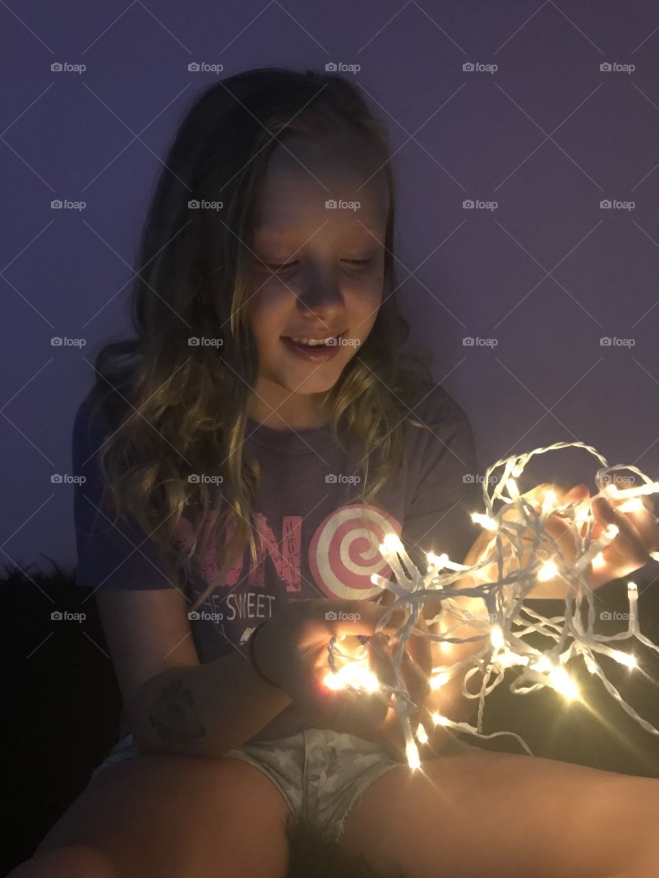 A happy beautiful goddess holding the lights of the world aka a person holding fairy lights 