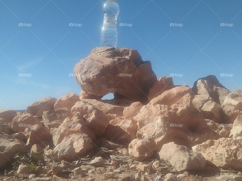 Beautiful bottle of water on a big rock.