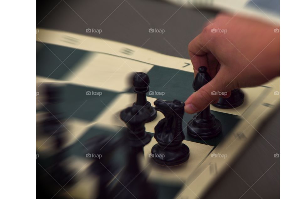 Hand grabbing black bishop chess piece during March 