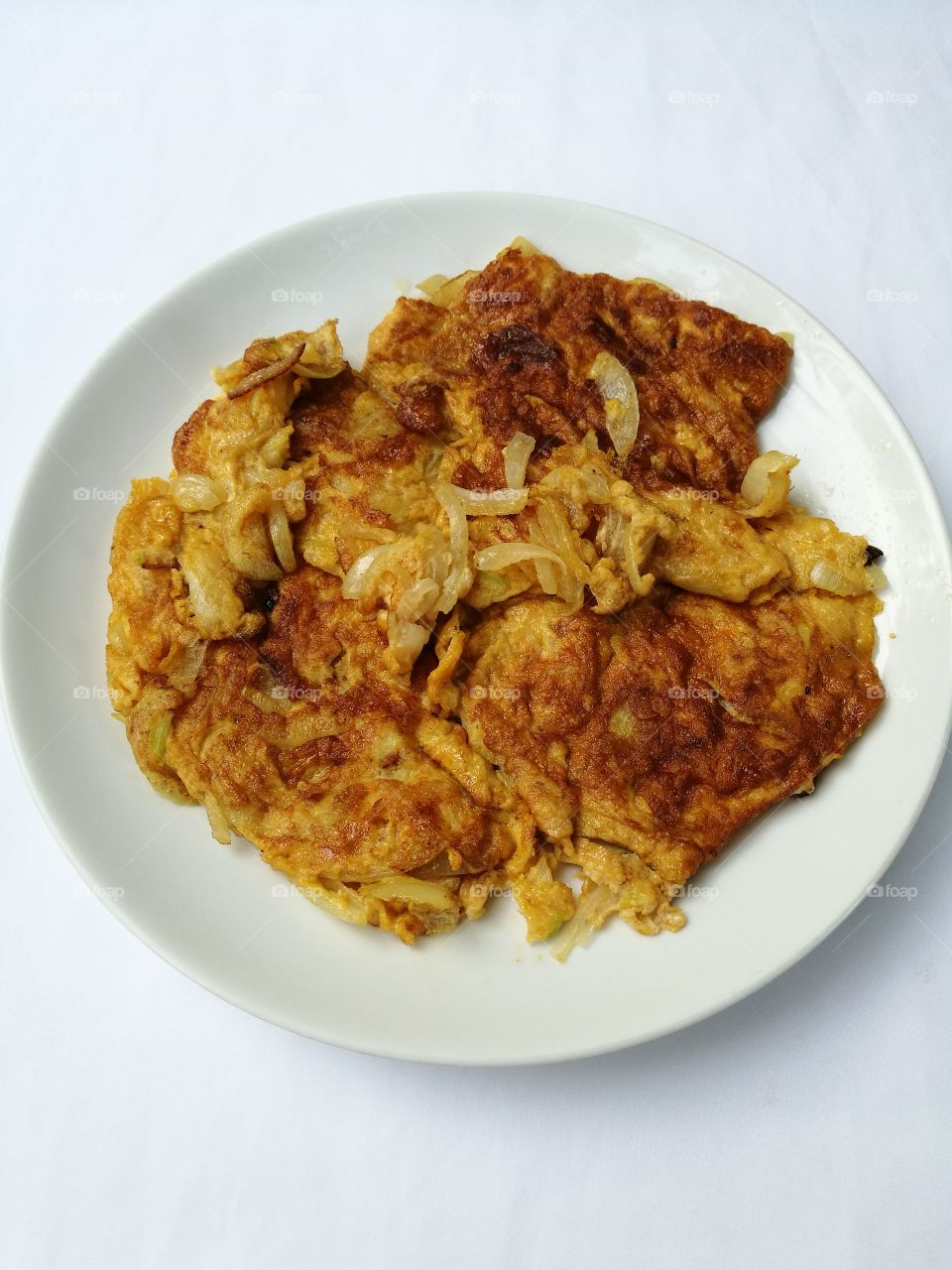 A plate of Thai omelette on white background.