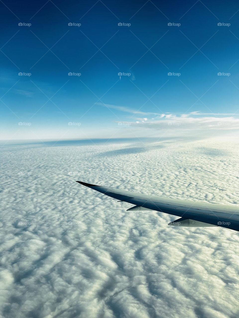 A photo from plane window showing the white clouds