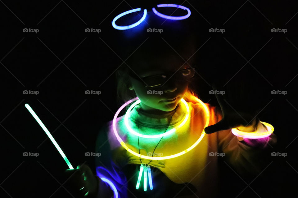 Child playing in the dark with glow sticks
