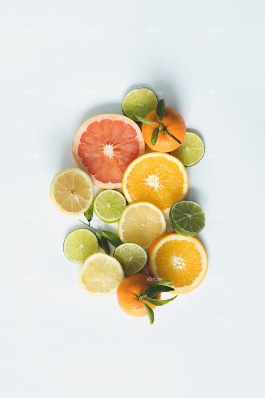 An overlay of crosswise slices of citrus fruit and two whole small oranges.