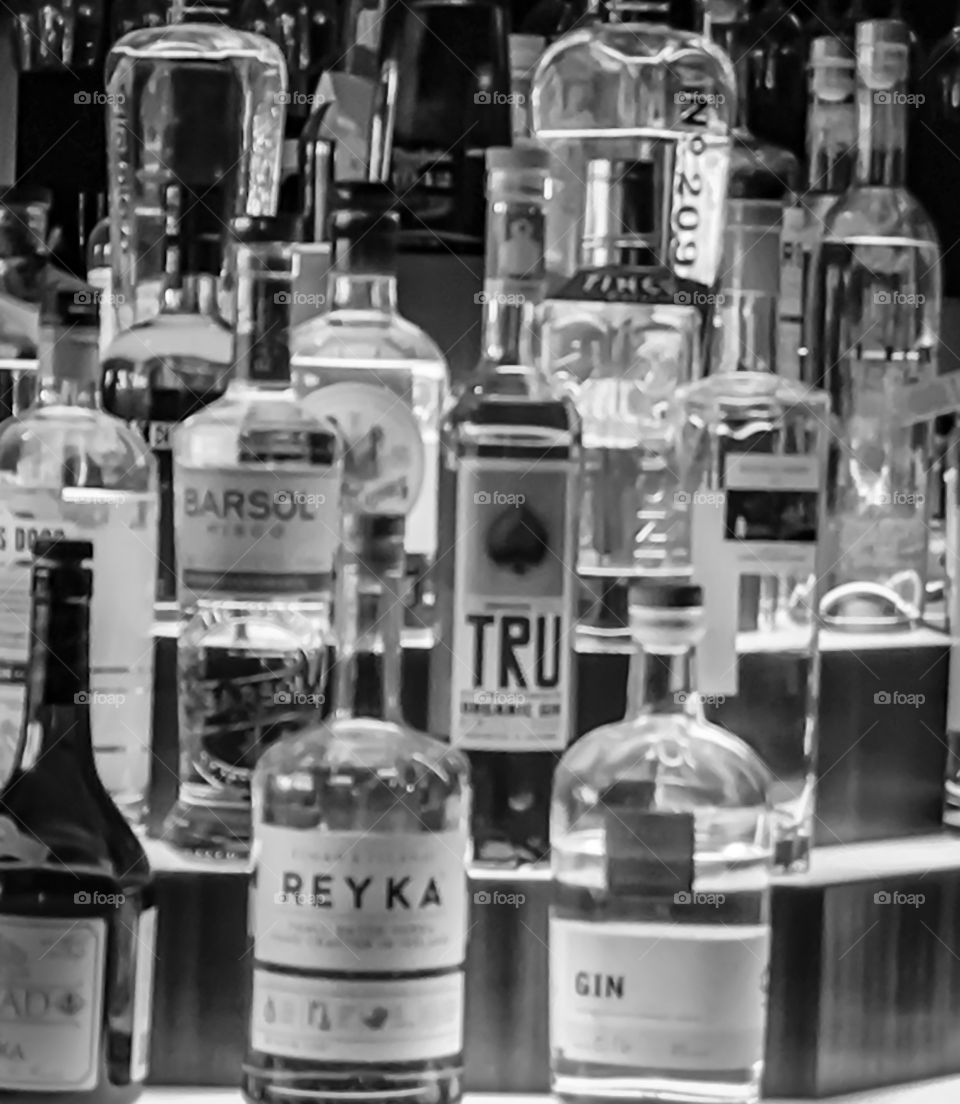 Black and white capture liquor bottles behind a bar