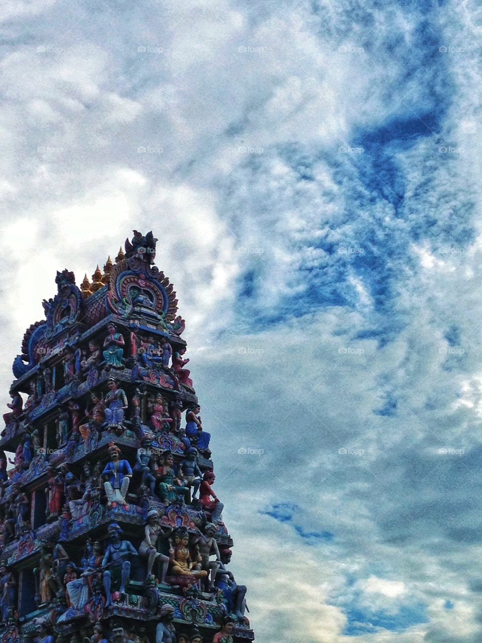 Indian temple against blue sky and clouds