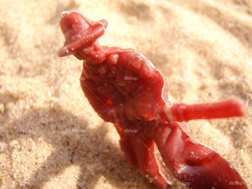 Cowboy at the beach. Plastic cowboy figure in the sand