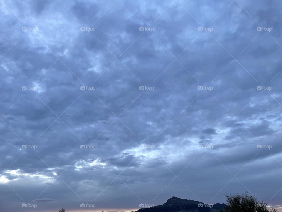 A very dark and cloudy sky with mountains below. 